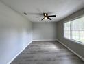 A spacious room with a ceiling fan, light gray plank flooring, and a window for natural light at 1102 Hampton Ct, Summerville, SC 29486