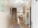 Inviting foyer featuring wood floors, a staircase, and views into the kitchen and dining area, creating an open feel at 116 W 2Nd St, Folly Beach, SC 29439