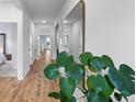 Bright hallway with hardwood floors, a stylish mirror, and a view into other rooms at 1173 Wading Point Blvd, Huger, SC 29450