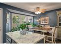 Kitchen island with granite countertop next to table seating and large windows with backyard views at 1414 E Crossing Ln, Mount Pleasant, SC 29466