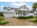Light blue house featuring a white garage, front porch with white railings, and well-maintained landscaping at 1740 Agate Bay Dr, Mount Pleasant, SC 29466