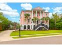 Elegant two-story home with grand entrance, columns, and meticulously landscaped yard, creating curb appeal at 2128 Breezy Point Dr, Mount Pleasant, SC 29466