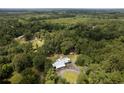 An aerial view of a lovely property with a house, barn, surrounded by lush, dense trees at 225 Baxter Ln, Walterboro, SC 29488