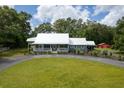 A charming exterior view of a single-story home featuring a welcoming front porch and a red barn at 225 Baxter Ln, Walterboro, SC 29488