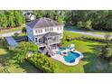 Aerial view of home with a screened porch, beautiful pool, surrounding foliage, and large green lawn at 3011 River Vista Way, Mount Pleasant, SC 29466