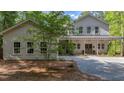 Charming two-story home with a covered front porch, two-car garage, and a gravel driveway nestled among mature trees at 32 Middleton Oaks Rd, Charleston, SC 29414