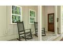 Inviting front porch with rocking chairs and views of the landscaped yard; perfect for relaxing outdoors at 32 Middleton Oaks Rd, Charleston, SC 29414