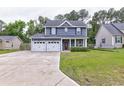 Charming two-story home with an attached two-car garage and a well-manicured front lawn at 321 Houston Dr, Ladson, SC 29456
