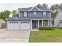 Charming two-story home with an attached two-car garage and a well-manicured front lawn at 321 Houston Dr, Ladson, SC 29456
