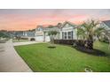 View of a home's large driveway, well-kept lawn and charming front exterior at 331 Fish Creek Ct, Summerville, SC 29486
