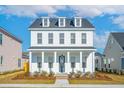 Charming two-story home featuring a welcoming front porch with classic white columns and a well-maintained yard at 365 Trailmore Ln, Summerville, SC 29486