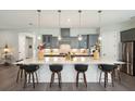 Modern kitchen with a large island, pendant lighting, and stainless steel appliances at 393 Tupelo Lake Dr, Summerville, SC 29486
