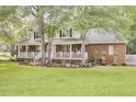 Beautiful two-story home with a covered front porch, a well-maintained lawn, and manicured garden beds at 4217 Meadowbrook Ct, North Charleston, SC 29420