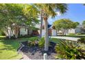 Well-maintained brick home with a lush front lawn and attractive landscaping, including palm trees at 486 Maple Oak Ln, Charleston, SC 29414