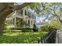 Exterior view of a yellow two-story home with black shutters and a well-manicured front yard at 5 Logan St, Charleston, SC 29401