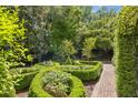 Garden view featuring manicured boxwoods and a brick pathway at 5 Logan St, Charleston, SC 29401