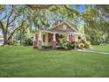 Inviting home with lush lawn, mature trees, and quaint porch, perfect for relaxation at 5126 Highway 174, Hollywood, SC 29449
