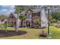 Charming two-story home with brick and siding exterior, complemented by lush landscaping and mature trees at 555 Pointe Of Oaks Rd, Summerville, SC 29485