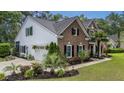 Two-story home with brick and siding, showcasing a well-manicured lawn and mature trees at 555 Pointe Of Oaks Rd, Summerville, SC 29485