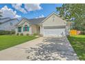 Inviting single-story home with well-maintained lawn, long driveway, and attached two-car garage at 6179 Fieldstone Cir, Charleston, SC 29414