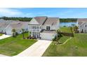 Picturesque two-story home with a front porch, attached garage, and a view of a lake at 682 Pontoon Rd, Huger, SC 29450