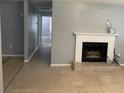 Bright living room with fireplace, tile floors, and hallway leading to a bathroom at 7733 Buck Pond Rd, North Charleston, SC 29418