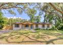 Charming single-story home featuring a white brick exterior, wood accents, and a beautifully landscaped front yard at 841 Fred St, Charleston, SC 29412