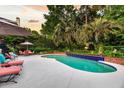 Gorgeous backyard pool with lounge chairs and patio furniture surrounded by lush landscaping and palm trees at 8662 W Fairway Woods Dr, North Charleston, SC 29420