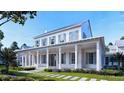 Stunning exterior elevation featuring a large porch, white siding, beautiful landscaping and meticulously crafted architectural design at 952 Mccants Dr, Mount Pleasant, SC 29464