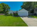 Well-kept one-story home featuring green lawn, mature shrubbery, and an attached two-car garage at 9590 Crosscut Dr, Ladson, SC 29456