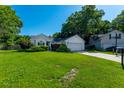 Well-maintained one-story home with a lush green lawn, mature landscaping, and a two-car attached garage at 9590 Crosscut Dr, Ladson, SC 29456