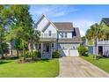 Charming two-story home features a landscaped yard, covered porch, and two-car garage at 104 Wando Reach Rd, Wando, SC 29492