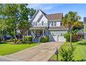 Charming two-story home with a well-manicured lawn and a convenient two-car garage at 104 Wando Reach Rd, Wando, SC 29492
