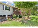 Close-up of home's entry shows beautiful landscaping and a welcoming front porch with an American flag at 1125 Oceanview Rd, Charleston, SC 29412