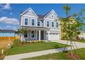 Charming two-story home with a well-manicured lawn, attached garage, and inviting blue door at 1215 Homecoming Blvd # Cc2-1-25, Ravenel, SC 29470