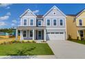 Charming two-story home with a well-manicured lawn, attached garage, and inviting blue door at 1215 Homecoming Blvd # Cc2-1-25, Ravenel, SC 29470