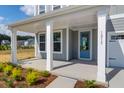 Inviting front porch with classic columns and a stylish blue front door and manicured landscaping at 1215 Homecoming Blvd # Cc2-1-25, Ravenel, SC 29470