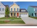Inviting yellow two-story home with a manicured lawn, white garage door, and bright orange front door at 1217 Homecoming Blvd # Cc2-1-26, Ravenel, SC 29470