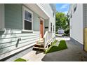 Inviting front porch with a peach colored door, leading to a well-maintained walkway at 15 H Street St, Charleston, SC 29403