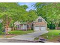 Attractive brick home featuring a lush front yard, mature trees, and a two-car garage at 1851 Oleander Ct, Charleston, SC 29414