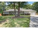 Charming single-story home with a well-manicured lawn, mature trees, and attached two-car garage at 19 Milano Ct, Hanahan, SC 29410