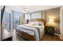 Comfortable bedroom with wooden frame bed, ceiling fan, and balcony access with stunning view at 201 W Arctic Ave # 406, Folly Beach, SC 29439