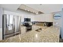 Modern kitchen with stainless steel appliances, granite countertops, and ample cabinet space at 201 W Arctic Ave # 406, Folly Beach, SC 29439