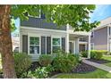 Charming home with black shutters, lush landscaping, and a welcoming front porch at 2025 Maybelles Ln, Charleston, SC 29414