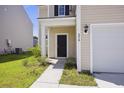 Home exterior featuring a charming front door, freshly landscaped yard, and an attached garage at 278 Catawba Branch Way, Moncks Corner, SC 29461