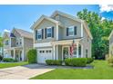 Charming two-story home featuring manicured lawn, gray siding and an inviting front porch with a US flag at 286 Chemistry Cir, Ladson, SC 29456