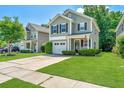 Charming two-story home featuring manicured lawn, gray siding and an inviting front porch with a US flag at 286 Chemistry Cir, Ladson, SC 29456
