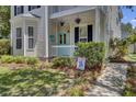 Inviting porch with turquoise door, white railing, and lush landscaping at 30 Regency Oaks Dr, Summerville, SC 29485