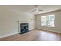 Cozy living room features wood floors, a window overlooking the backyard, and a fireplace at 3073 Penny Ln, Johns Island, SC 29455