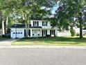Inviting two-story home with a well-kept lawn, white siding, black shutters, and a basketball hoop above the garage at 3784 Scotts Mill Dr, North Charleston, SC 29420